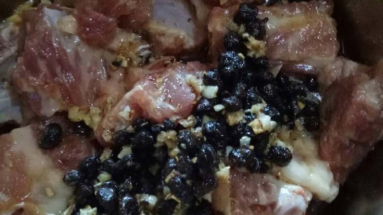 豆豉蒸排骨,煸过的蒜蓉豆豉拌入排骨中,搅拌均匀(喜欢吃辣的,小红椒可以多备两朵,这时候一起拌入排骨中,我不吃辣所以小红椒用来点缀而已)