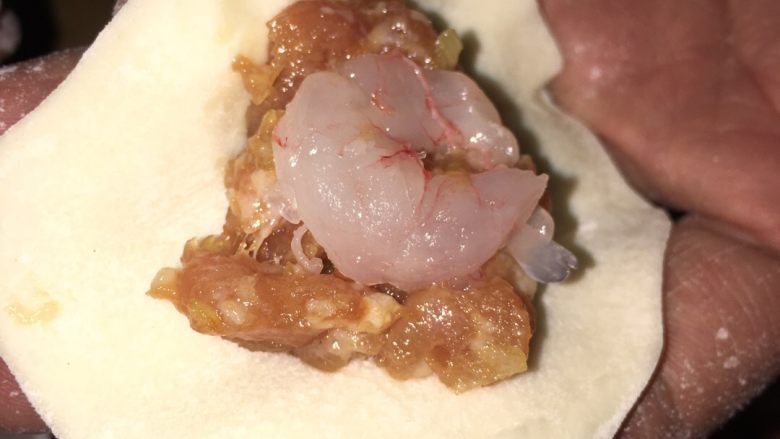 鲜虾猪肉水饺,在肉馅中间放入一个虾仁,按在肉馅里。