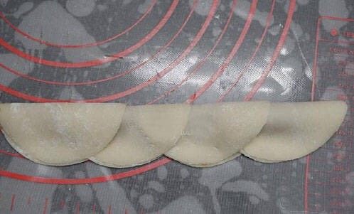 玫瑰花煎饺,肉馅放置均匀,将饺子皮对折,轻轻按压肉馅部分,不让有不均匀的地方鼓起来,注意不要太用力