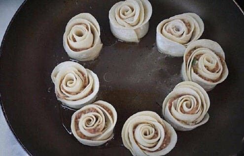 玫瑰花煎饺,将平底锅中放少许油,加热煎一分钟,饺子地步黄色即可加水