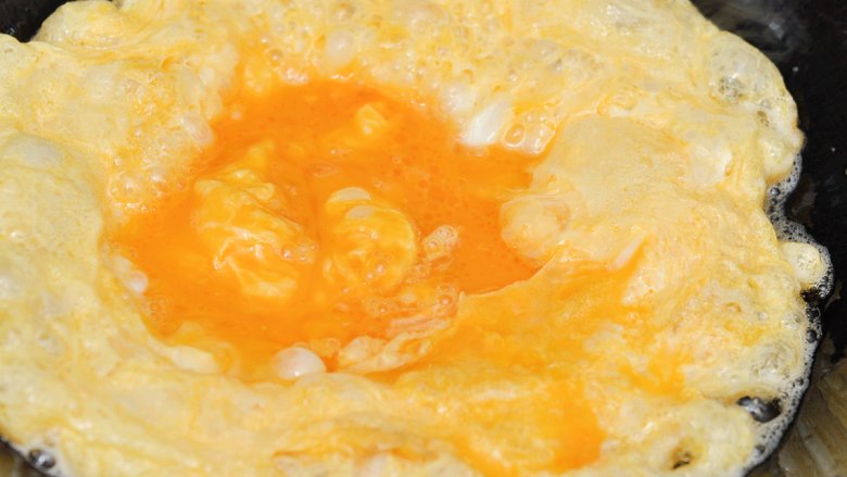 洋葱炒鸡蛋,锅中油热后倒入鸡蛋液，至表面金黄后盛出