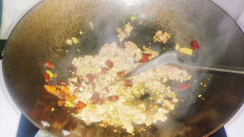 干煸豆角,油锅热后，倒入葱姜蒜花椒干辣椒大料，爆香。然后倒入肉馅，少许酱油。将肉馅炒熟。