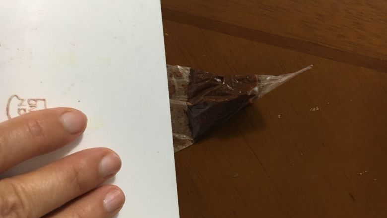麋鹿小蛋糕#乐享双节#,裱花袋剪一小口,用刮刀把巧克力糊赶在袋尖