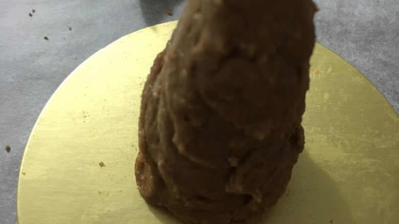 可可松果#乐享双节#,把粘合剂抹在饼干上,做成一个锥形的桩,放在底托上固定