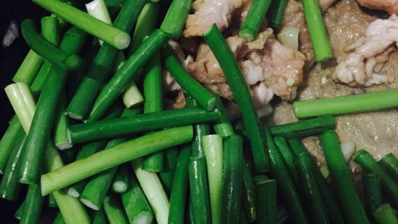 蒜苔炒肉,倒入蒜苔翻炒