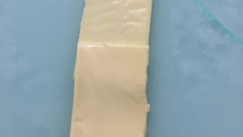 乳酪火腿面包,面团松弛期间我们来做馅料:把乳酪片对半切开,两片叠放在一起,放上<a style='color:red;display:inline-block;' href='/shicai/ 8817'>脆皮肠</a>。