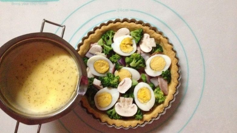 西兰花培根咸派,将馅料的食材铺满在烤好的派皮上,倒入馅料液至9分满