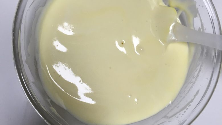 酸奶蛋糕,取三分之一打发好的蛋白混入面糊，画十字切拌，倒入蛋白盆中，搅拌均匀。
