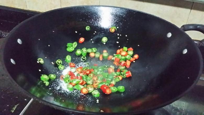 青红椒煎焖鲩鱼,青、红椒切圈,锅烧热,放入椒圈,加适量盐,干煸炒。