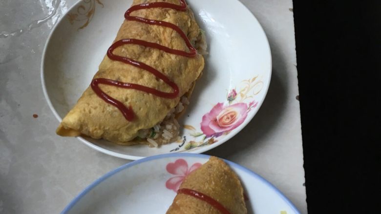 蛋包饭,将饭包入饼里面，挤上番茄酱即可