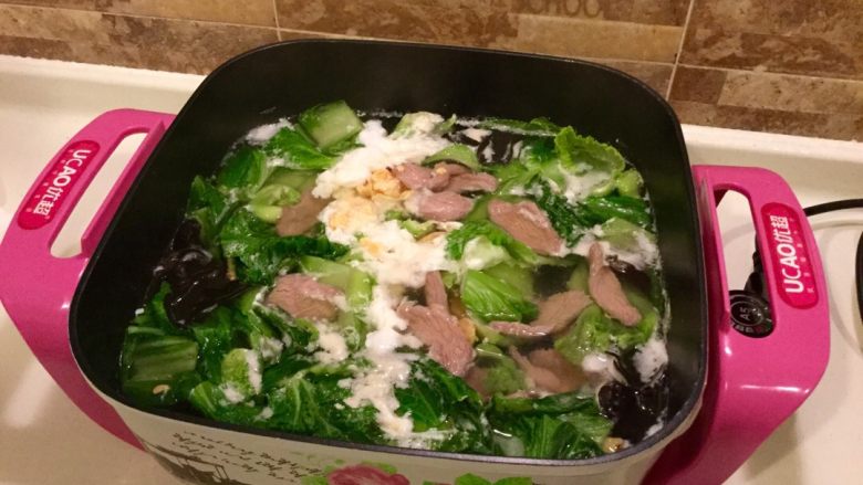 芥菜咸鸭蛋肉片汤,开锅后,打入两个咸鸭蛋,三分钟后加入芥菜叶子,木耳,开锅后加入肉片煮一分钟左右,肉片熟了加入盐,胡椒粉,油,关火完成