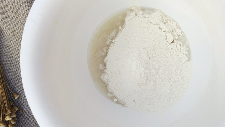 当主食一次可以吃三个的法棍面包,将混合均匀的粉类倒入溶解的酵母水里,倒入一半左右。