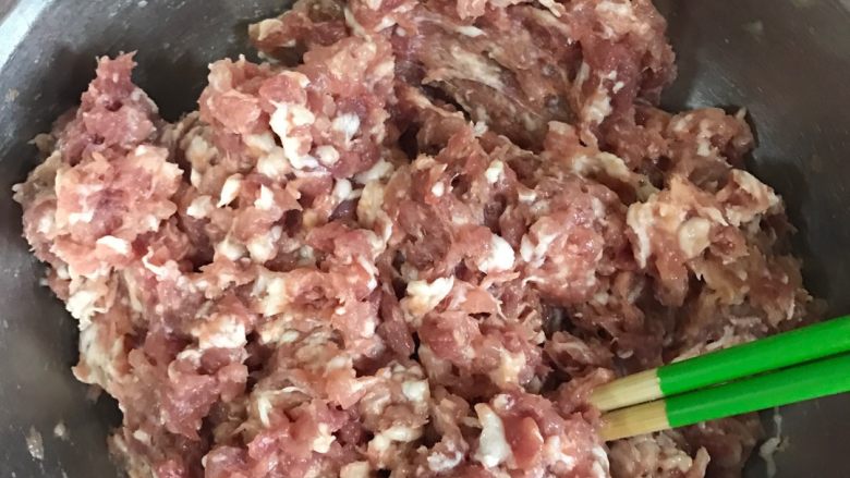 莲菜猪肉饺子,在肉馅里打一个鸡蛋,顺时针搅拌均匀