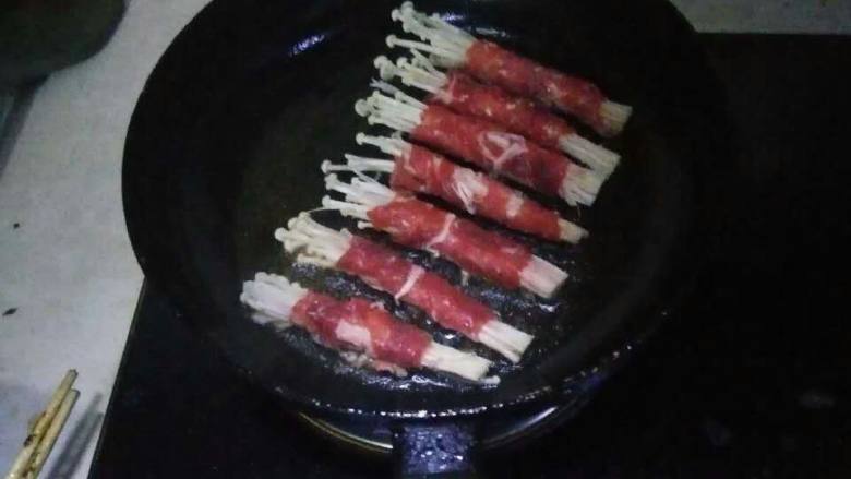 肥牛金针菇,平底锅里放入适量食用油，烧热后放入肉卷