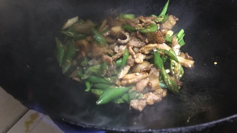 农家小炒肉 湘菜,辣椒炒熟后,把锅边的肉跟辣椒一起翻炒。需要不停的翻炒哦!让辣椒入味。肉不至于味道很重。辣椒跟肉烧熟后。这时候加入<a style='color:red;display:inline-block;' href='/shicai/ 2794'>大蒜</a>段。再次提味。
