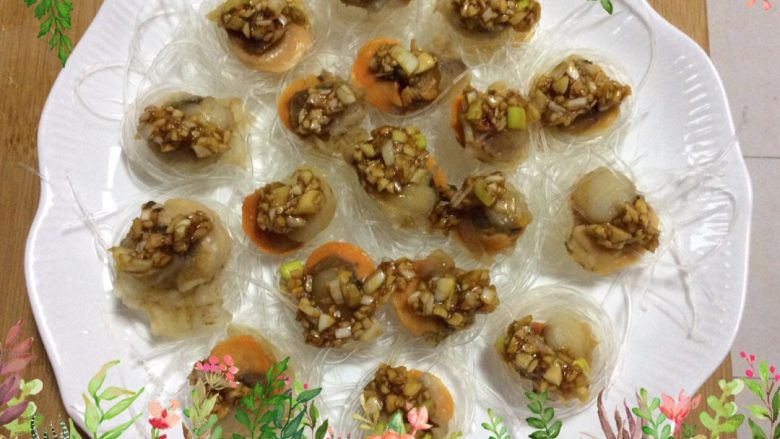 “年夜饭”蒜泥粉丝蒸扇贝肉,把调好的蒜末分别洒在扇贝肉上，锅开后上笼蒸5分钟