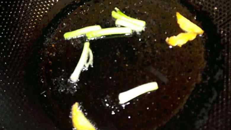 #年夜饭#油焖大虾,锅中倒入约2汤勺的油,放入葱段和姜片,待煎至姜片收缩,葱段变成褐色取出