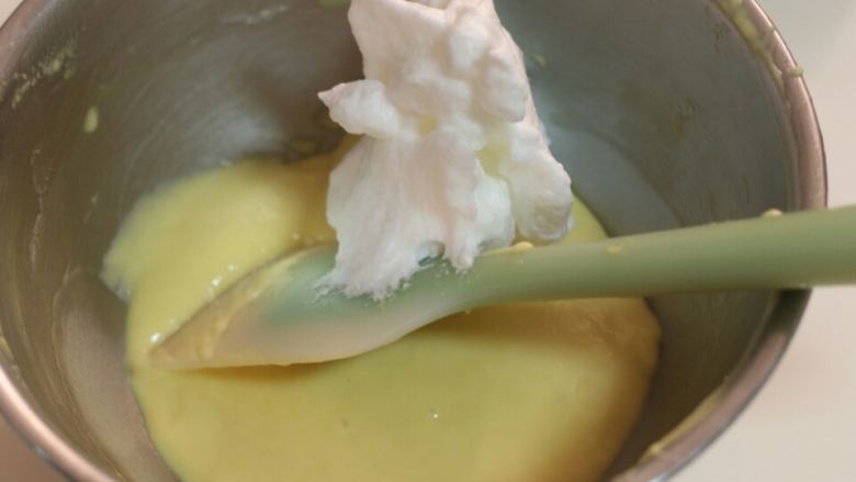 培根戚风,取1／3蛋白加入蛋黄中拌匀。