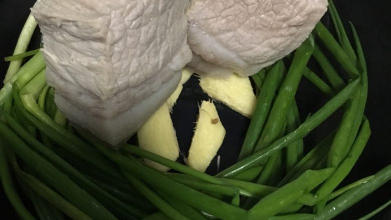 #年夜饭#东坡肉,砂锅内放上葱和<a style='color:red;display:inline-block;' href='/shicai/ 37'>姜</a>片，肉皮向下码好肉块，放入<a style='color:red;display:inline-block;' href='/shicai/ 866'>冰糖</a><a style='color:red;display:inline-block;' href='/shicai/ 894'>黄酒</a><a style='color:red;display:inline-block;' href='/shicai/ 762'>老抽</a><a style='color:red;display:inline-block;' href='/shicai/ 788'>生抽</a>，适量的开水，大火烧开后转小火焖炖约1小时