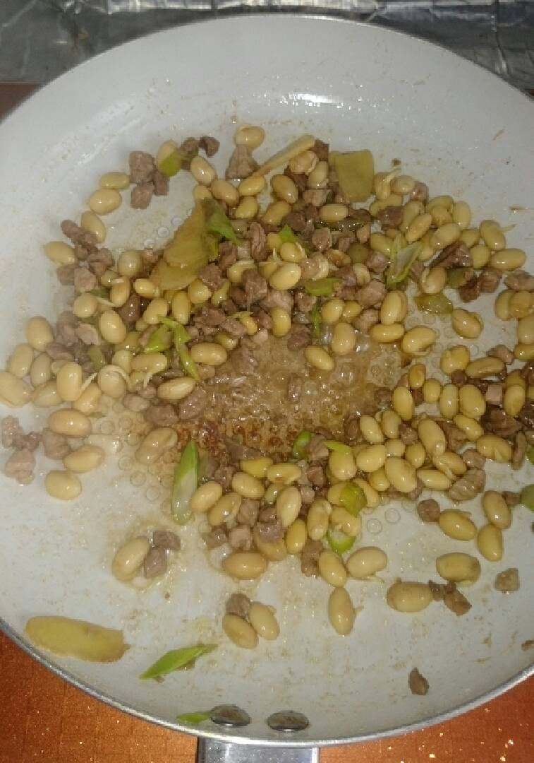 家常猪肉豆丁,倒入黄豆,翻炒几下即可。