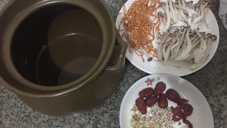 虫草花鸡汤,一个煲汤的砂锅、辅料以及新鲜的虫草花和鸡腿骨
