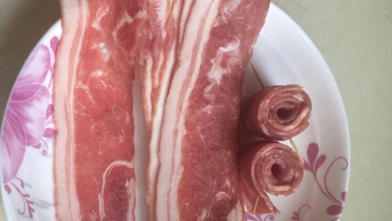 培根什锦蛋炒饭,培根肉片卷成小卷,用牙签固定。