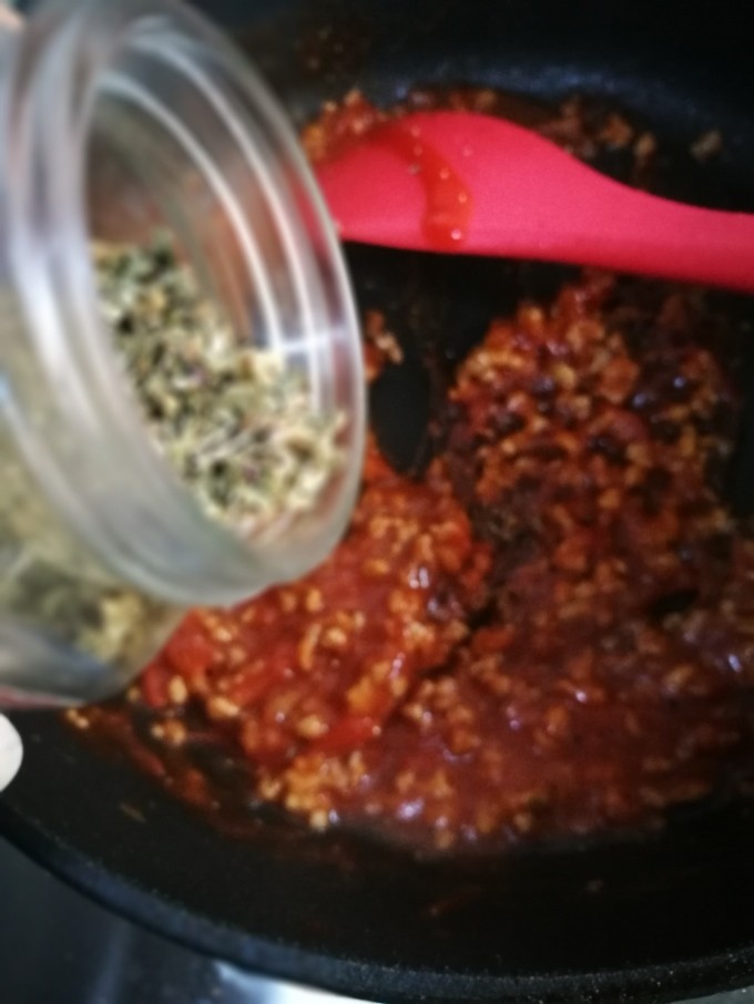 萨拉米白香肠培根薄底披萨(平底锅版),最后可以加入黑椒碎和罗勒碎,使酱料更浓郁。(这是加罗勒碎,加黑椒碎就不上照了)这个可以加可以不加。