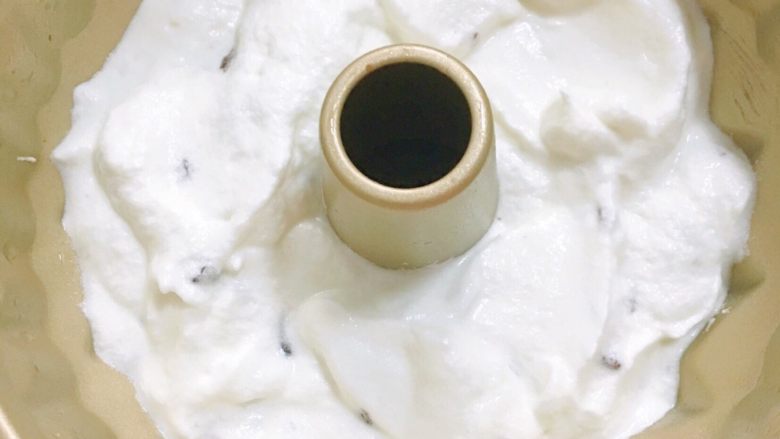 透着新年红的蔓越莓天使蛋糕,模具里面刷一层玉米油,从高处缓缓倒入拌匀的蛋白糊,震几下,震出大气泡。