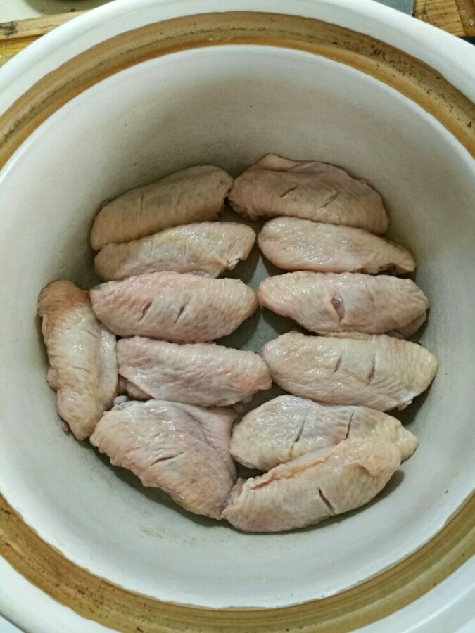 南瓜焖鸡翅（来自食谱，塔吉锅真的很牛，10分钟完全搞定）,先把翅中洗净，表面用刀划两刀，以便淹制时入味。