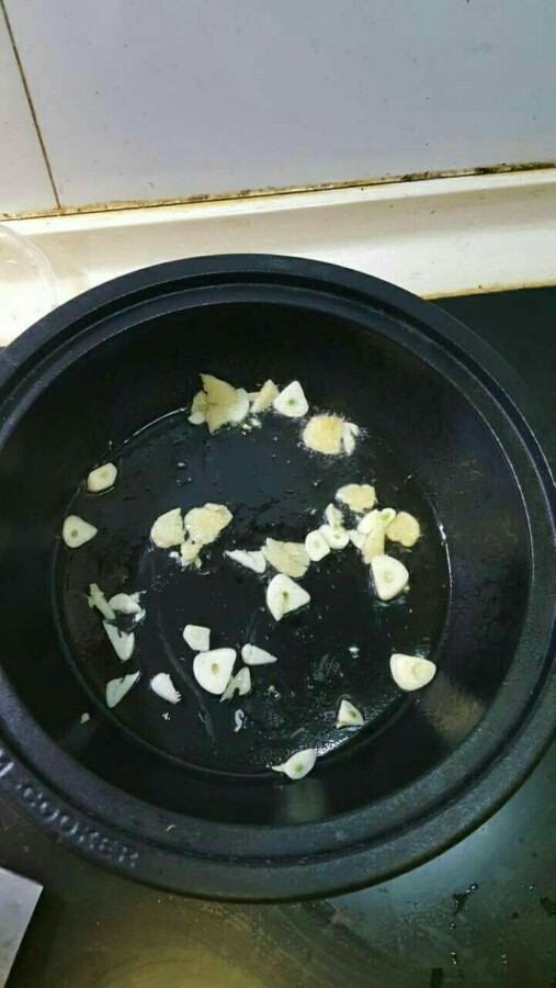 南瓜焖鸡翅（来自食谱，塔吉锅真的很牛，10分钟完全搞定）,准备好后，开火，热锅，倒油平铺锅底，放姜蒜，到出味。