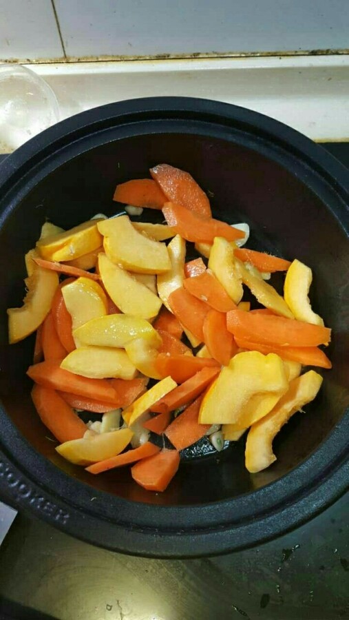 南瓜焖鸡翅（来自食谱，塔吉锅真的很牛，10分钟完全搞定）,把南瓜片和胡萝卜片放进去。