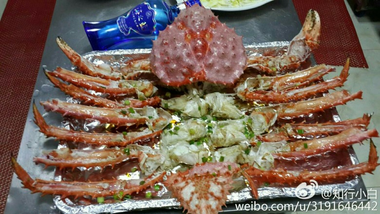 豉油皇蒸帝王蟹,摆盘,放姜丝葱末,豉油皇汁,淋热油。上桌来吃。