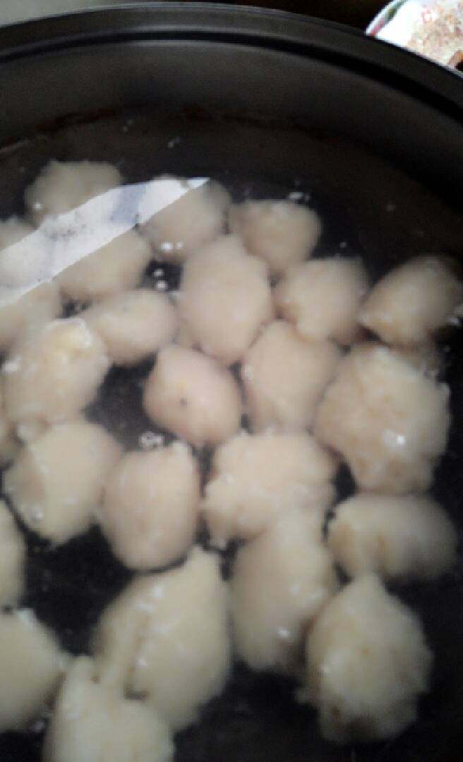 自制草鱼丸,鱼丸做好后,把锅放燃气灶上煮,鱼丸浮起来就做好了。