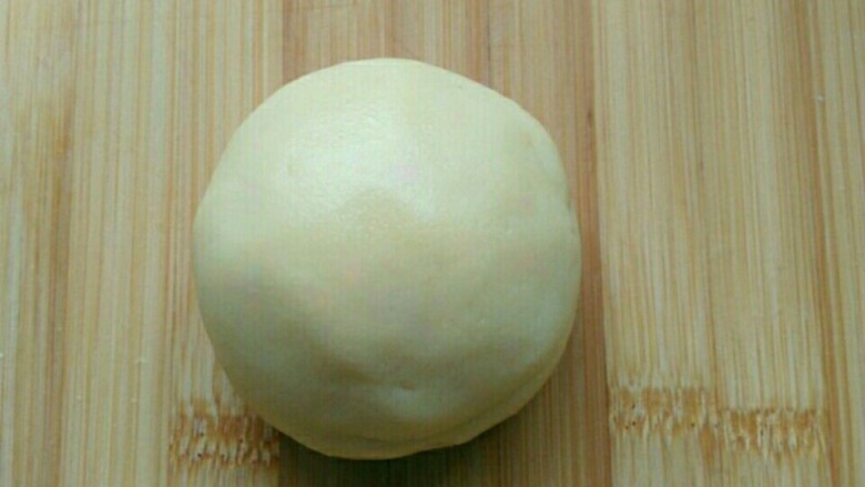 烧果子蛋糕,然后将原味面团滚圆,压扁,中间放入<a style='color:red;display:inline-block;' href='/shicai/ 475'>红豆沙</a>,收口朝下。