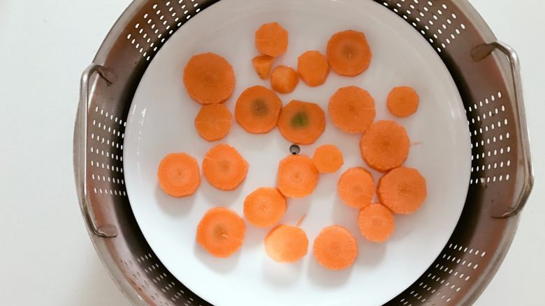 宝宝辅食:胡萝卜香蕉奶昔-7M ,把胡萝卜平摊放入蒸锅,大火蒸熟取出,小芽蒸了大概15分钟,大家根据自己切的大小和火力调整时间哈。