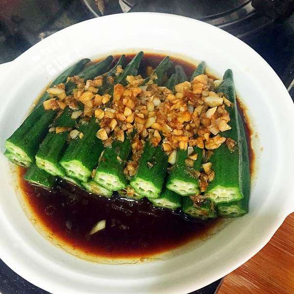 蒜蓉秋葵,将秋葵码在盘里,浇上酱汁和蒜蓉,然后用热油浇上即可。