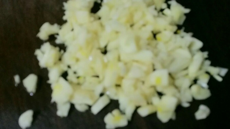 椒圈拌腰花,将大蒜切剁成细粒,放在椒圈上。