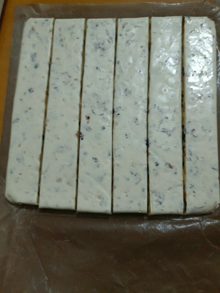 抹茶白巧牛轧糖,切成均匀的大条~这个步骤一定要在砧板上面切,底下可以垫油纸或者不垫都可以,但是一定不能在油布上面切,会烂的!!!