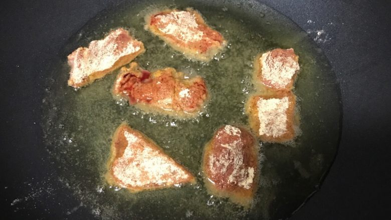 干炸牛肉,油烧至八成热时转小火,放入肉片。
