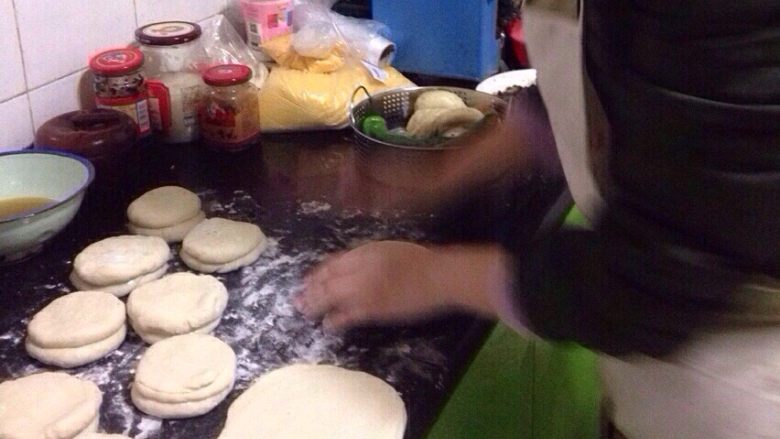 烫面饼子,将面条切成小块,用手压扁,中间涂抹上熟油,将面饼两两相对。