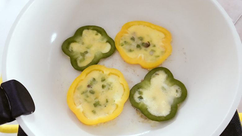 宝宝辅食:彩椒鸡蛋圈-18M ,用勺子将步骤3中的混合鸡蛋液舀入彩椒圈内,注意不要放太满,齐平或九分满即可,煎的过程中鸡蛋液会稍稍膨胀,太满溢出影响最终成品颜值。