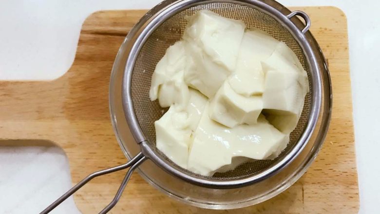 宝宝辅食:豆腐酸奶饮-12M ,内脂豆腐放在筛网中,放入沸水中煮5-6分钟,用筛网捞出简单沥水,稍加冷却。
》内脂豆腐划成小块好一点哈。