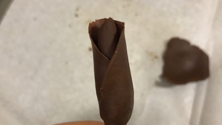 手工巧克力玫瑰花,再压一片裹在花芯上,花瓣的边缘可以用手再次捏薄,这样更逼真。