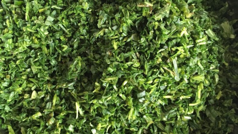 野菜疙瘩,切碎如图。为了野菜出水分，撒点盐，如果野菜控水不太干的话也可以不撒盐。为了野菜蒸出的颜色绿油油的话，撒少许食用碱，当然也可以不用撒