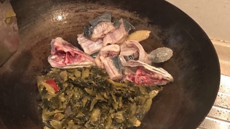 酸菜鱼,锅中倒少量油,将生姜放入油锅,然后将鱼骨和鱼头放入油锅,将鱼骨稍微煎炸下,然后将鱼骨拨到一边,放入酸菜翻炒下,然后把鱼骨和酸菜一起翻炒,之后向锅中倒入适量水,加适量料酒,然后将酸菜鱼调料包中的调料倒入锅中,煮沸之后过1-2分钟,将其倒入备好的盆中。