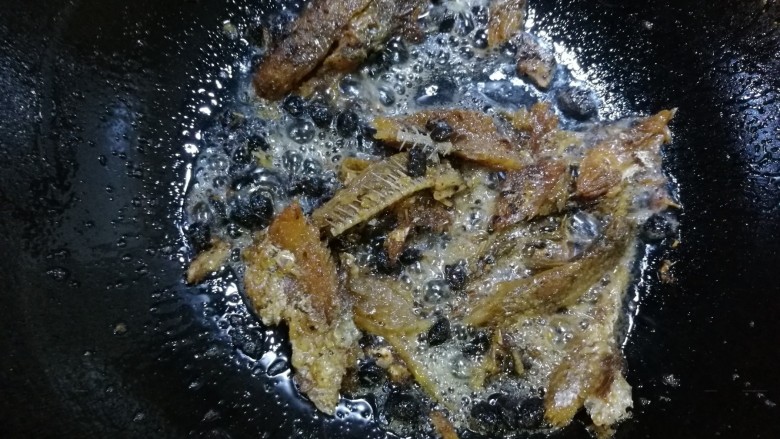 豆豉鲮鱼油麦菜,倒入准备好的豆豉鲮鱼,中火煸炒,用铲子将大块鱼肉铲碎,多炒一会,炒出香味