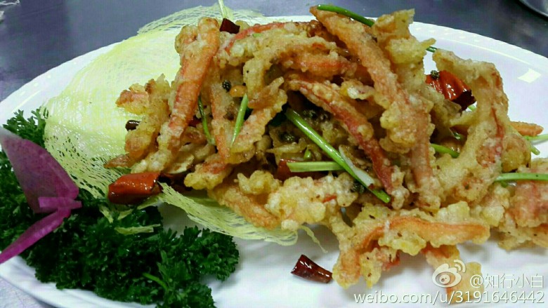 香煸阿拉斯加蟹腿肉,麻椒,辣椒,葱姜炝锅,放香菜花生米和炸好的蟹腿肉炒勻摆盘。