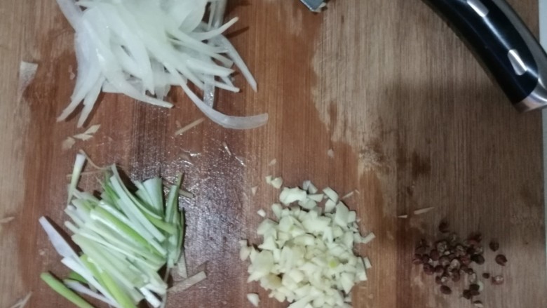 炝土豆丝,烫土豆丝的过程中将食材切好,葱切丝,蒜拍扁,切丁,洋葱切丝