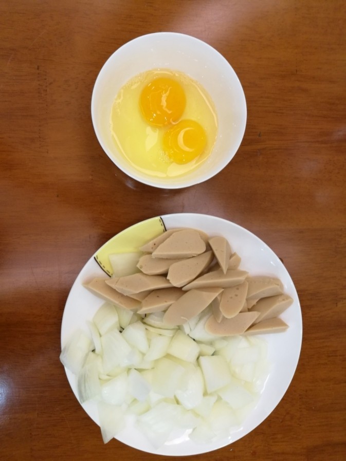 圆葱炒鸡蛋火腿,准备材料，<a style='color:red;display:inline-block;' href='/shicai/ 2573'>圆葱</a>切成方块，<a style='color:red;display:inline-block;' href='/shicai/ 437'>火腿肠</a>切滚刀块