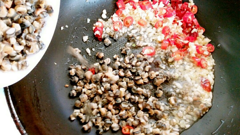 蒜苔炒螺丝肉(香辣版),然后把螺丝肉倒入锅内,调成中火,把螺丝肉炒制五分钟左右,期间如怕糊锅,也可往锅内点少许的水。